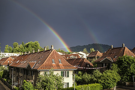 landscape photography of village under rainbows thumbnail