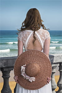 woman holding round beach hat thumbnail