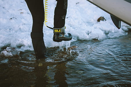 person in water carrying surfboard thumbnail