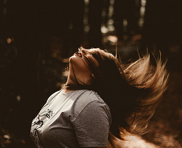 woman in gray crew-neck top waving her hair up during daytime thumbnail