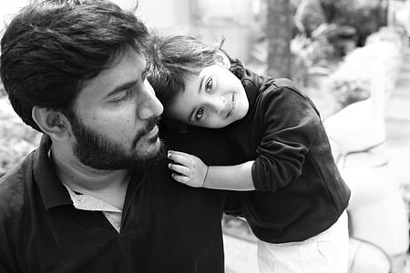 grayscale photography of toddler resting head on mans shoulder thumbnail