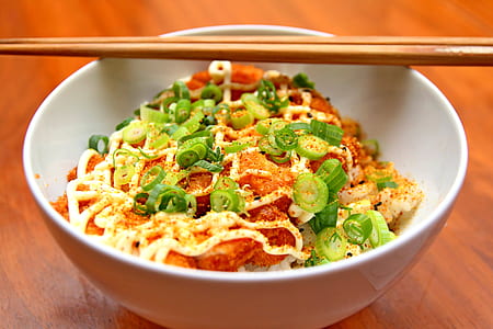 Brown Wooden Chopsticks on White Ceramic Bowl with Pork Cutlet and Spring Onion on Brown Wooden Table thumbnail