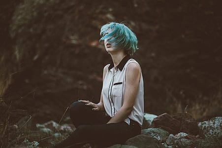 woman sitting on rock surrounded by trees painting thumbnail