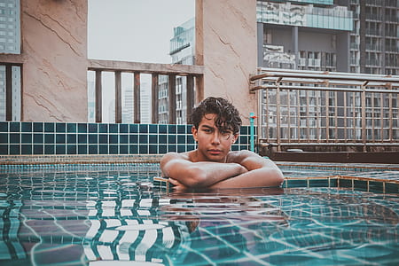 man in swimming pool posing for photo during daytime thumbnail