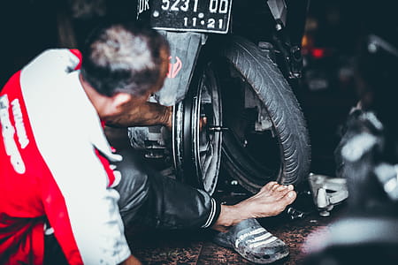Man Changing a Rear Tire of a Motor Scooter thumbnail