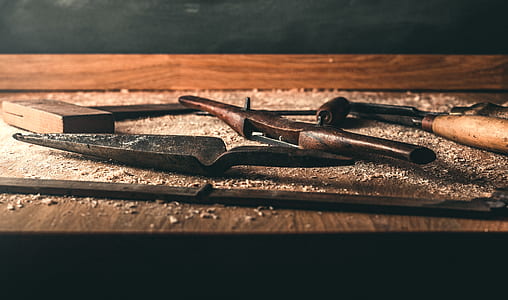 assorted hand tools on brown wooden table thumbnail