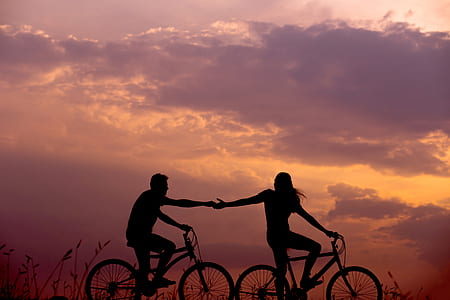 silhouette of man and woman ride on bike thumbnail