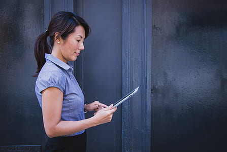 woman in gray collared shirt holding tablet computer thumbnail