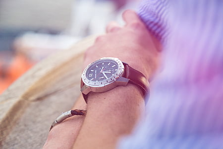 shallow focus photography of round analog watch with black leather strap on person's wrist thumbnail