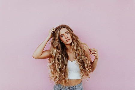 woman touching her brown curly hair thumbnail