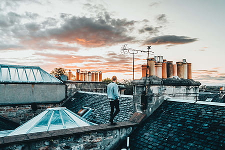 person standing on roof under cloudy sky thumbnail