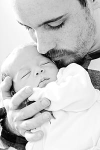 grayscale photography of man holding baby thumbnail