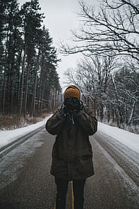 person holding black DSLR camera standing on road thumbnail