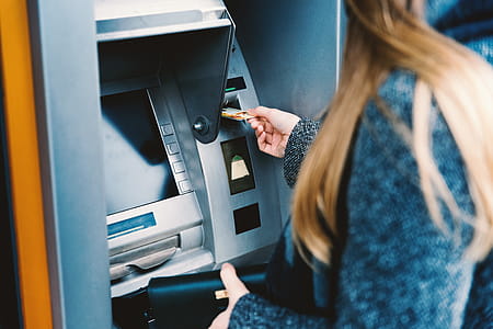 Young woman withdrawing money from credit card at ATM thumbnail