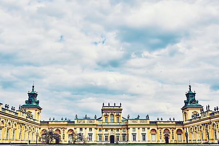 yellow concrete building under white sky at daytime thumbnail