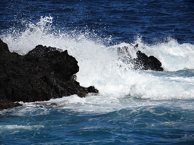 high waves crashing rock formation at daytime thumbnail