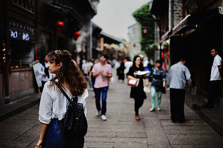 group of people walking in street between houses thumbnail