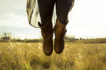 person at grass field wearing pair of brown boots thumbnail