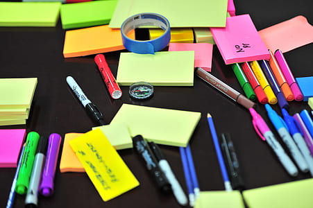 Photo of Sticky Notes and Colored Pens Scrambled on Table thumbnail