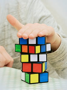 person with hand on top of Rubik's Cube thumbnail
