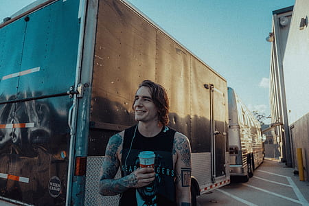 man in black tank top standing in front of black enclosure trailer thumbnail