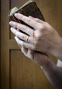 person holding bible and rosary thumbnail