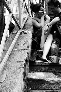 man sitting and laughing with woman sitting on stairs thumbnail