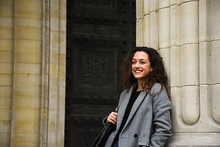 woman leaning on a gray concrete building thumbnail