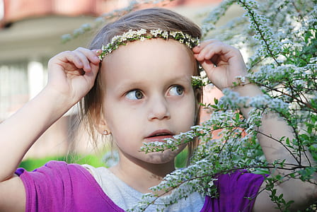 girl wearing purple and grey top holding white flowers thumbnail