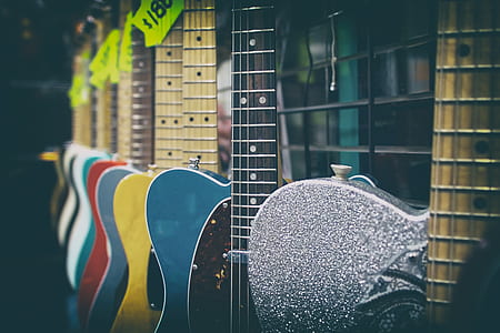 shallow focus photography of assorted guitars thumbnail