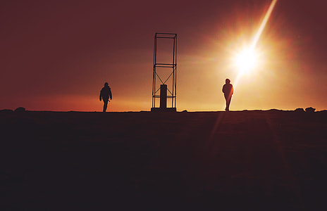 two person standing between scaffolding during sunset thumbnail