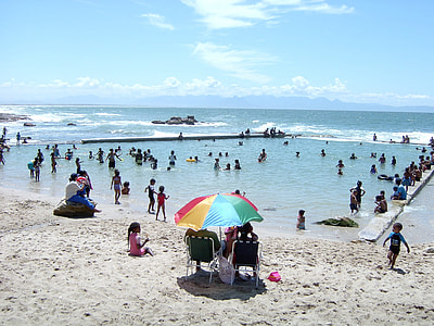 two person sitting on chair under multicolored umbrella during daytime thumbnail