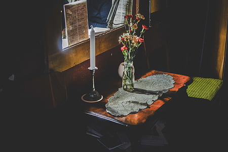 candle beside vase on table thumbnail