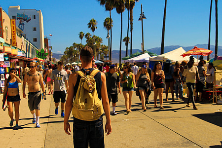 man standing on road watching people walking in front thumbnail