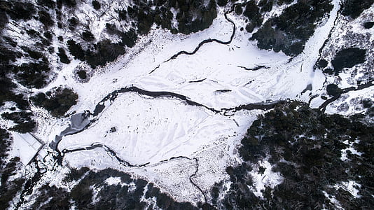 aerial photography of island covered with snow and surrounded by green leafed trees during daytime thumbnail