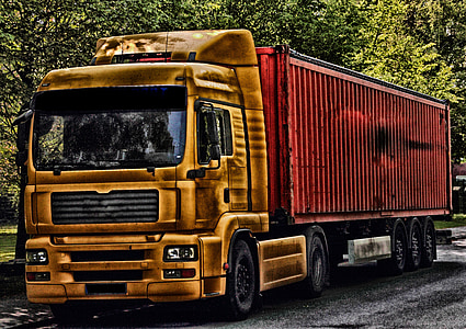 yellow truck beside trees during daytime thumbnail