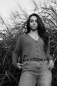 Grayscale Photography of Woman Standing Near Tall Plants thumbnail