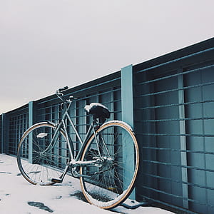 black commuter bike leaning on green metal frame thumbnail