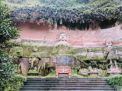 brown and green deity statues under trees thumbnail