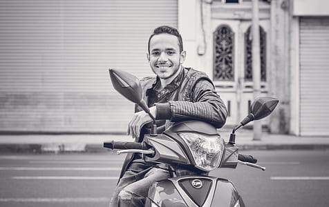 Grayscale Photography of Man Sitting on Motorcycle thumbnail