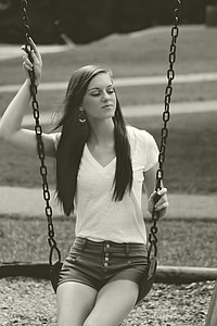 woman wearing white v-neck t-shirt sitting on swing chair thumbnail