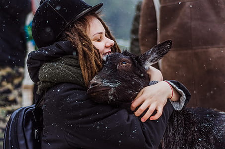 woman wearing coat hugging black goat thumbnail