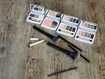 two makeup brushes beside makeup palettes thumbnail