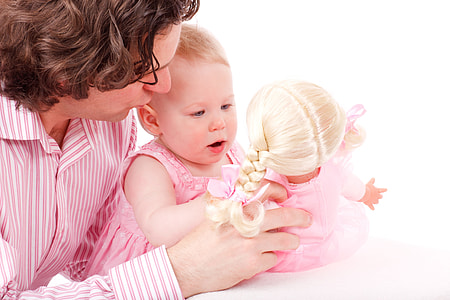 man wearing pink pinstripe dress shirt holding baby in pink dress holding blonde doll thumbnail