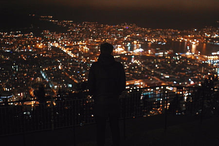 man standing on roof looking through city buildings thumbnail