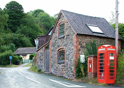 telephone booth beside house and road thumbnail