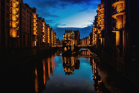 photo of body of water surrounded by high-rise building during night thumbnail