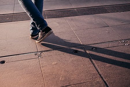 shadow of man wearing sneakers and jeans thumbnail