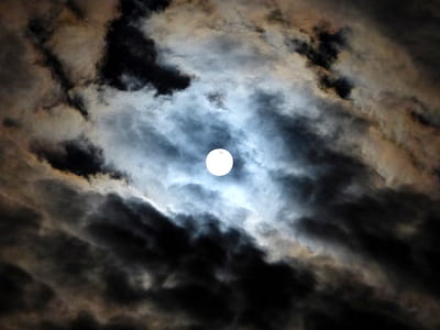 low-angle photography of moon near white clouds and blue sky thumbnail