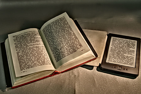 open book beside black tablet on brown textile thumbnail